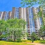 High-rise apartment building with surrounding trees.
