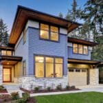 Modern house with large windows and driveway.