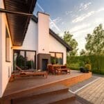 Modern house with wooden deck at sunset.