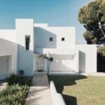 Modern white house with green lawn.