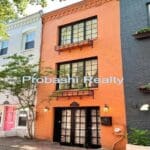 Colorful row houses with trees and windows.