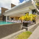 Modern house with pool and tropical plants.