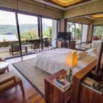 Luxury bedroom with ocean view and balcony.