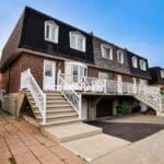 Brick townhouse with white stairs and railings.