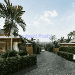 Tropical villa with palm trees and driveway.