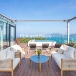 Rooftop terrace with ocean view and furniture.