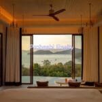 Bedroom with ocean view at sunset.