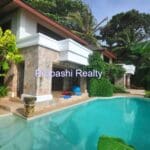 Luxury villa with pool and lush greenery.