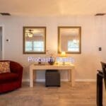 Living room with red chair and mirrors.