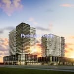 Two modern high-rise buildings at sunset.