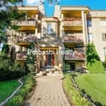Brick apartment building with landscaped entrance.