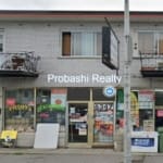 Small storefront with apartments above, daytime.