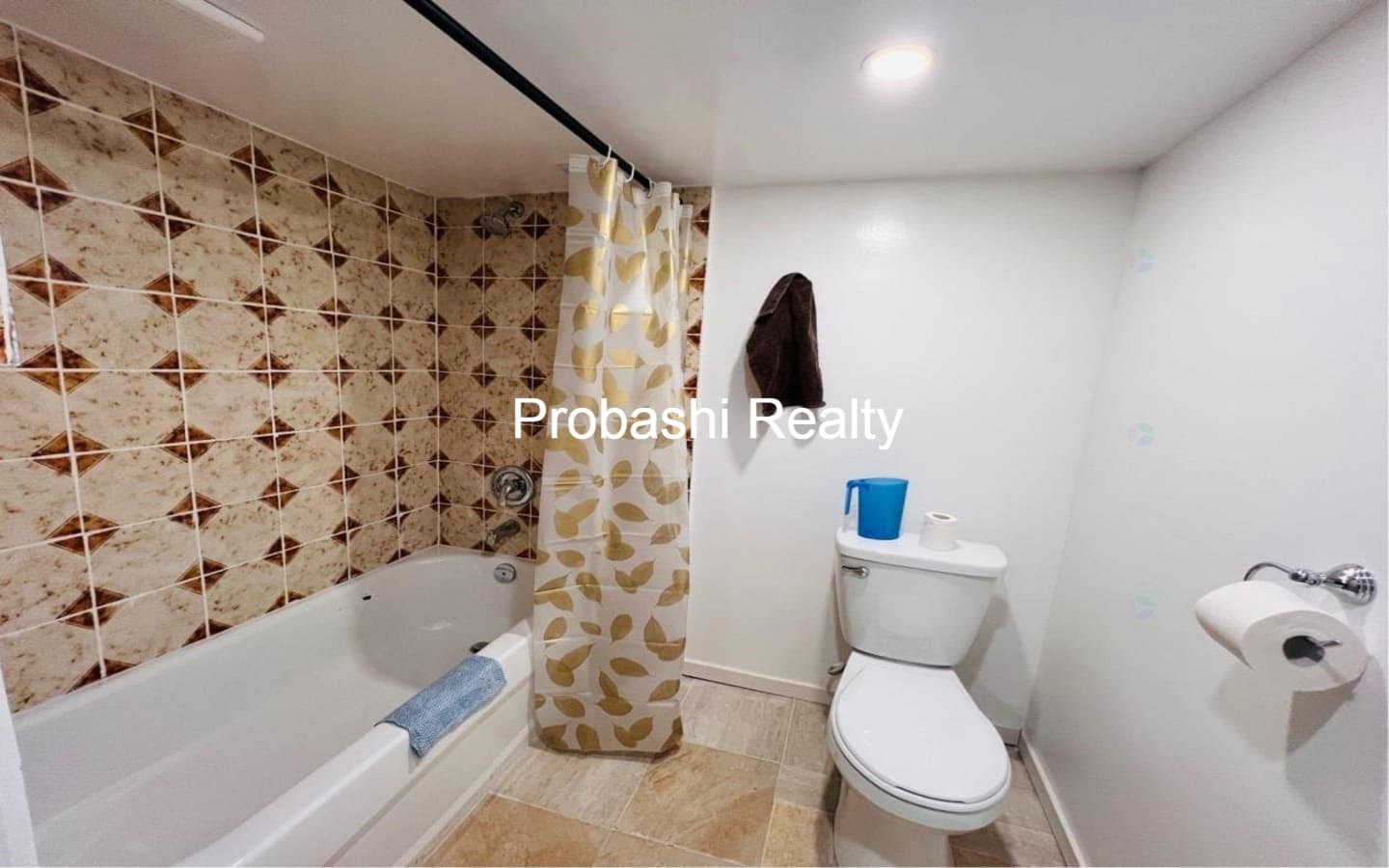 Small bathroom with tub, shower curtain, and toilet.