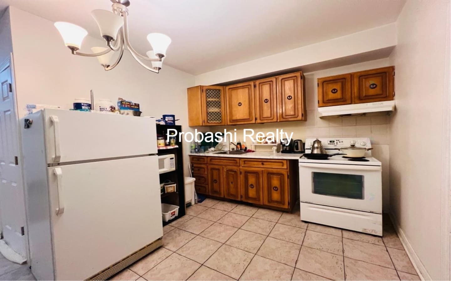 Cozy kitchen with wooden cabinets and white appliances.
