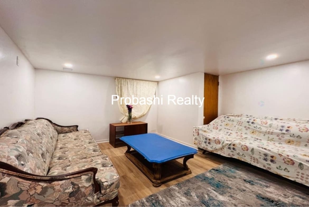 Cozy living room with floral sofas and a blue ottoman.