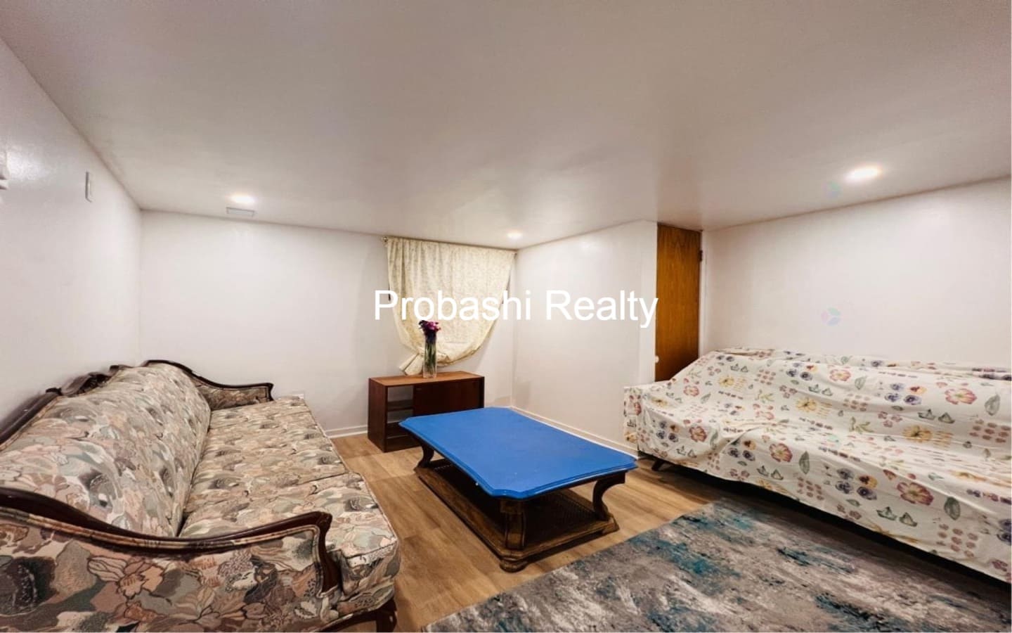 Cozy living room with floral sofas and a blue ottoman.