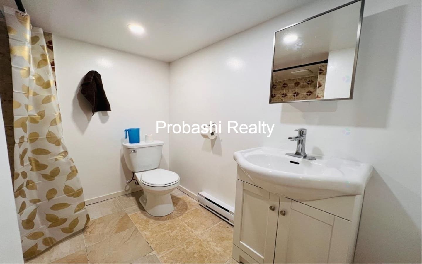 Clean bathroom with toilet, sink, and mirror.