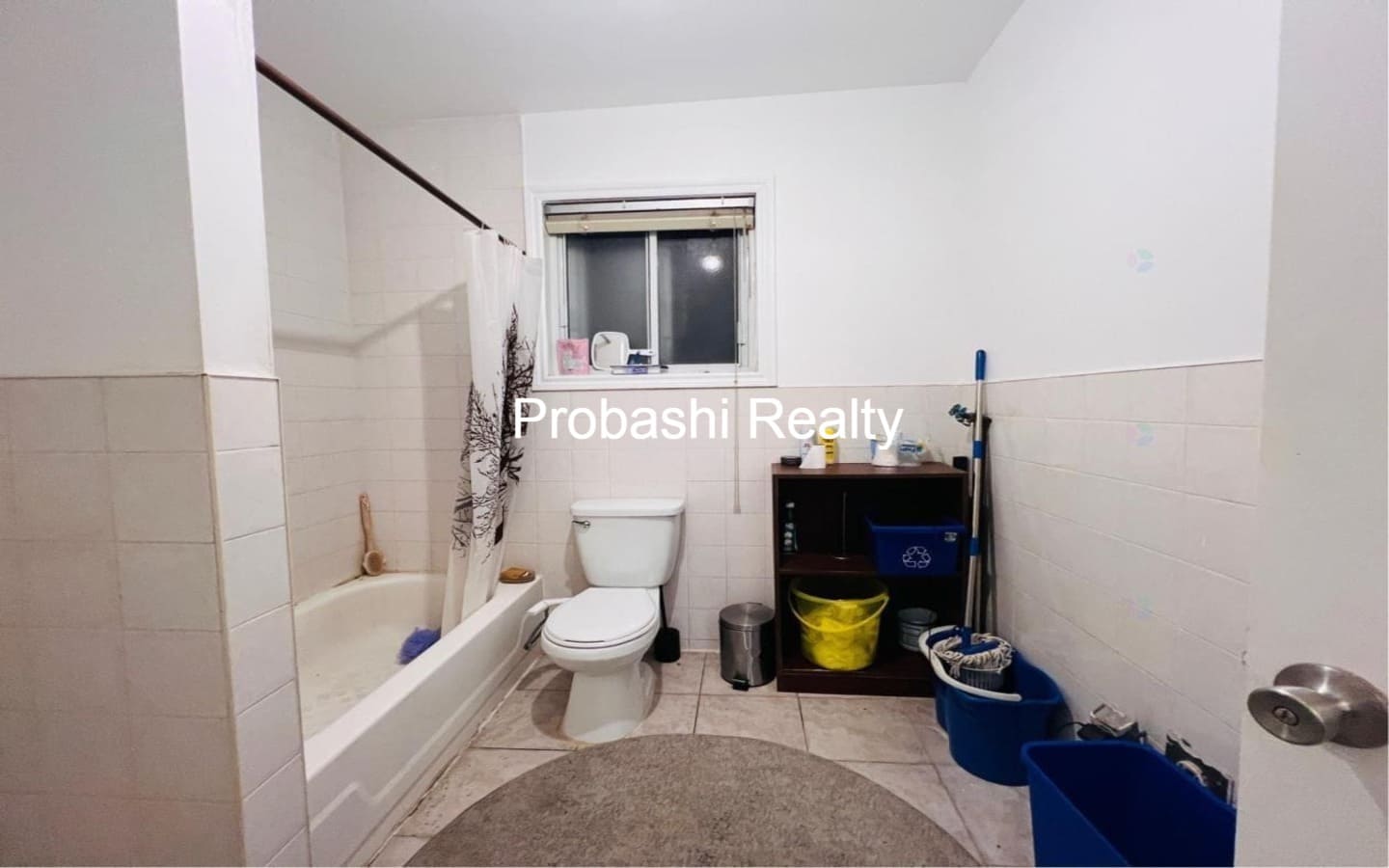 Bathroom with bathtub, toilet, and storage shelves.